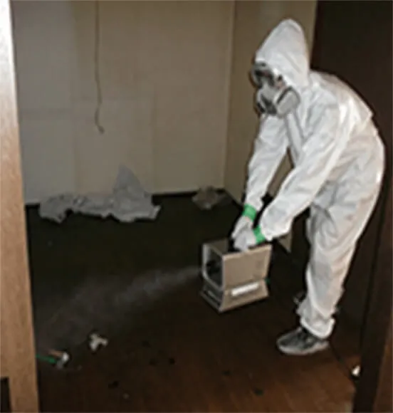 白い白衣を着て害虫駆除の薬剤を投与する職員