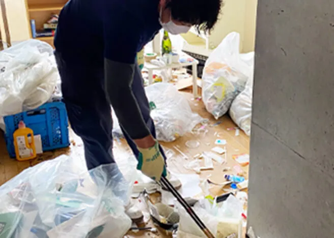 部屋のゴミ掃除をする社員