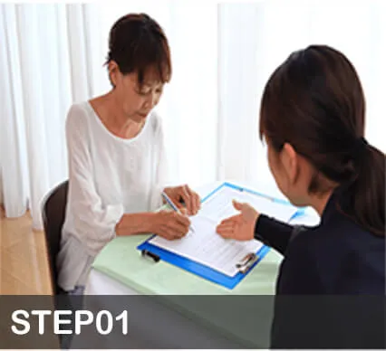 スタッフの説明を聞きながら書類を確認する女性