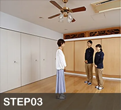 荷物を取り払った部屋に立つ3人の成人