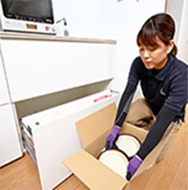 食器を丁寧に箱詰めするスタッフ