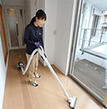室内を掃除機で清掃するスタッフ