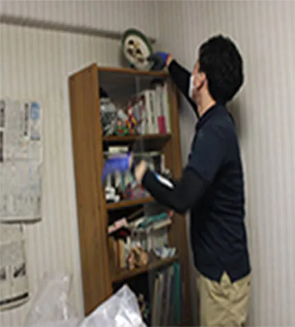 高いところの片付けを行う職員