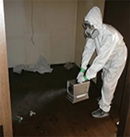 白い白衣を着て害虫駆除の薬剤を投与する職員